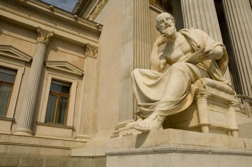 white greek naked statue sitting on white chair